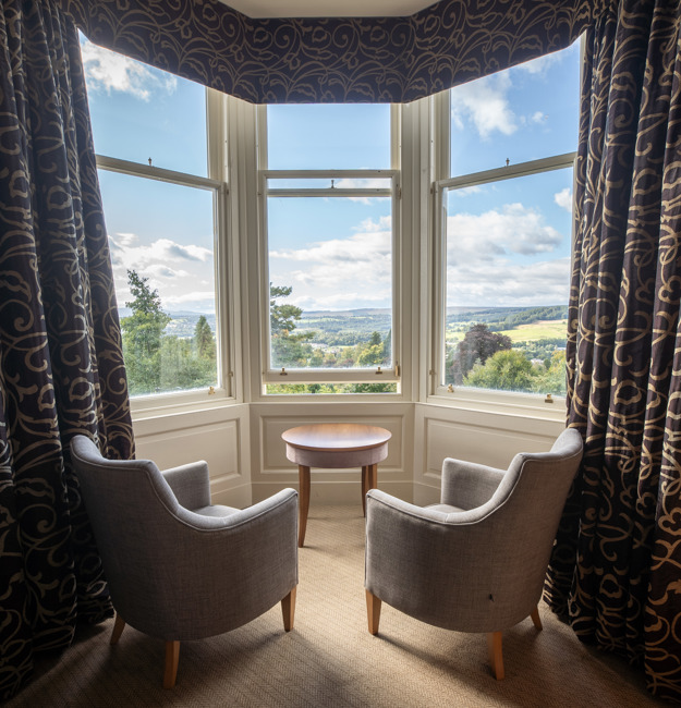 Feature Family room with two chairs facing a bay window