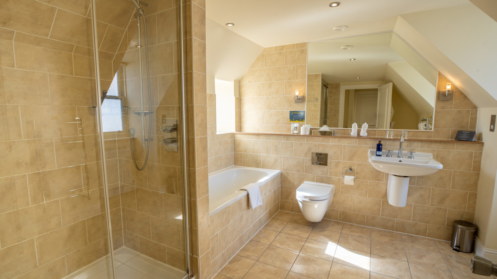 Bathroom with separate shower and bath, toilet, sink and mirror.